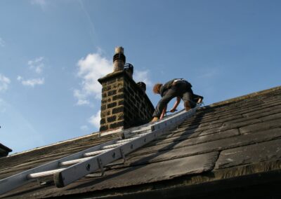 Roofer working on a stone chimney stack