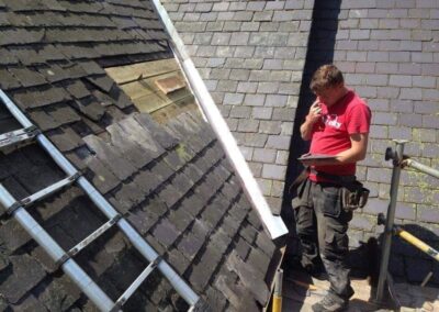 Roofer inspecting a slate roof before repair