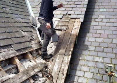 Roofer repairing slates on a pitched roof