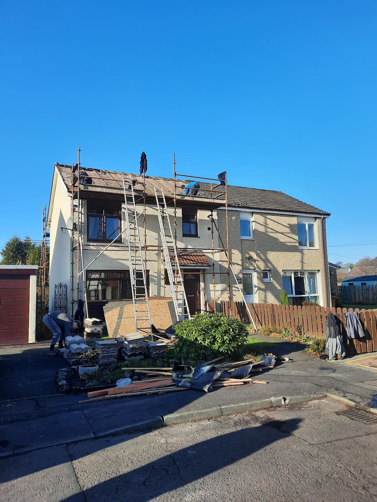 House under scaffolding during roughcasting work