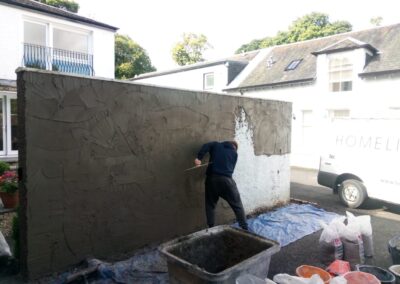 Roughcaster applying a new coat to a wall